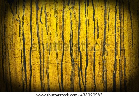 Vertical streaks of black oil on the yellow tank background. Abstract background with black lines on a yellow background.