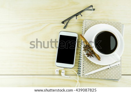 Smart phone, coffee,glasses and book with white pen on wood table background. top view and business concept