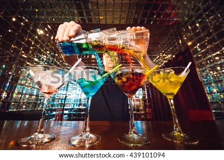 Barman show. Bartender pours alcoholic cocktails. Royalty-Free Stock Photo #439101094
