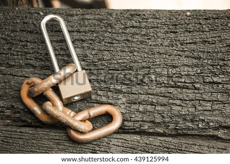 Lock and chain on wooden background