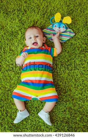 baby in colorful pajamas playing with mother