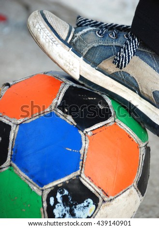 foot on a soccer ball , colorful, old , ragged. love this game concept