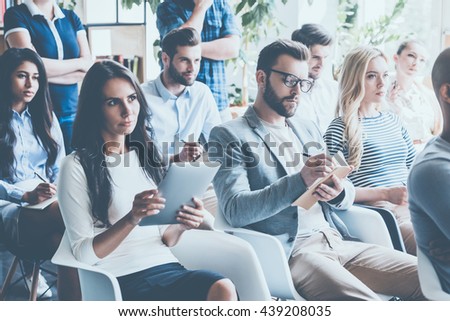 People on conference. Group of young people sitting on conference together and making notes Royalty-Free Stock Photo #439208035