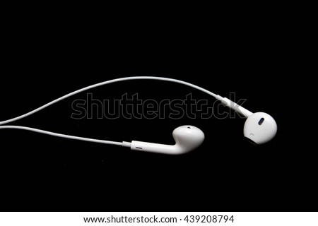 White headphones with plug isolated on black background