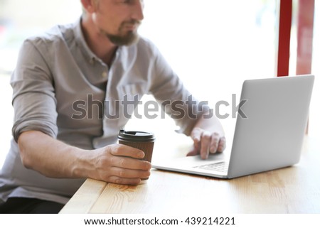 Businessman working with laptop in cafe