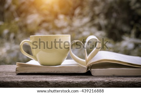 Pages of a book curved into a heart shape.heart of the book.coffee background,old book page decorate to heart shape for love in valentine day. Royalty-Free Stock Photo #439216888