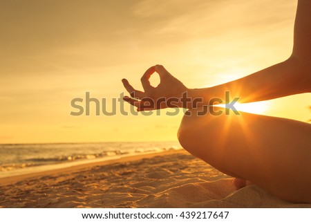 Woman meditating on the beach.  Royalty-Free Stock Photo #439217647