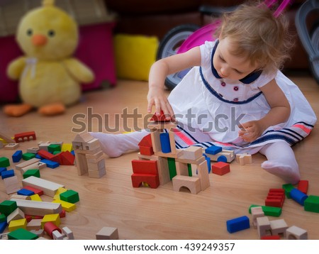 Two-year old caucasian girl playing with wooden blocks.