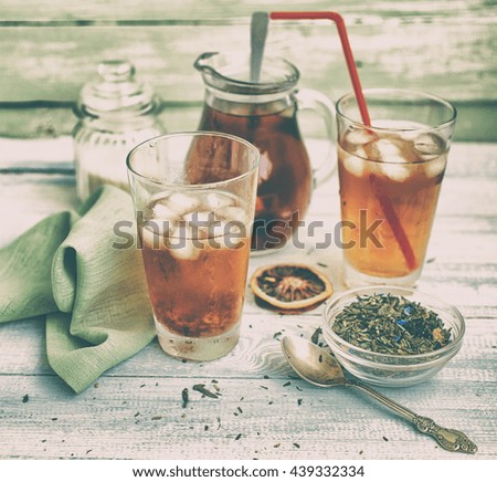 Cold tea on a wooden background. Ice tea. Cold drink. Vintage toning