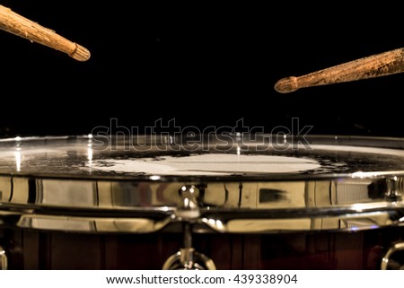 working drum with drum sticks, musical instrument on black background