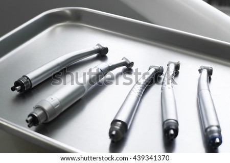 Dental turbine handpieces on metal tray closeup. Top view on ready for using set of dental tuebine handpieces on mesical tray. Royalty-Free Stock Photo #439341370