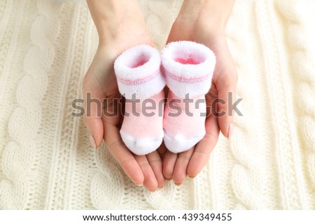 Woman holding baby socks, closeup
