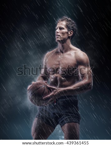 Shirtless basketball player under rain drops.