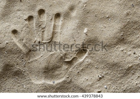 A Hand Print on Dirty Sand. Left Hand.