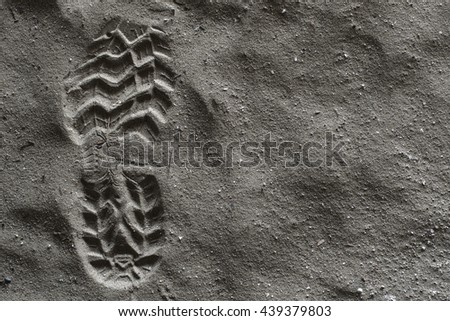 Close up boot or shoe print, left foot with grip set deeply into dirty sand, left side. Hdr picture.