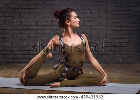 Young Beautiful Woman Practicing Yoga Doing Excercise Against A Brick Wall