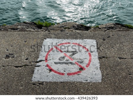 No Swimming Sign Painted on Crumbling Sidewalk