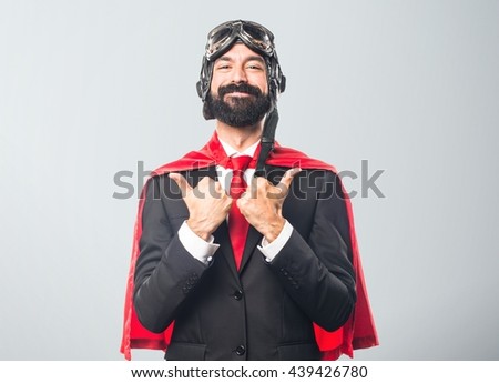 Super hero businessman with thumb up over grey background