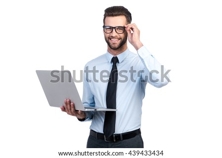 Confident business expert. Confident young handsome man in shirt and tie holding laptop and smiling while standing against white background