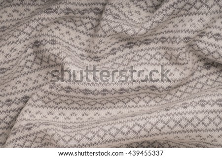 White wool knitted fabric with gray ornament. Textures, background