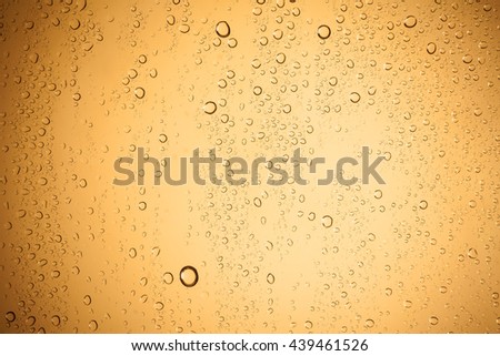 Water droplets on brown glass for a background.