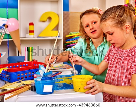 Two school girl keep brush painting on table in primary school .