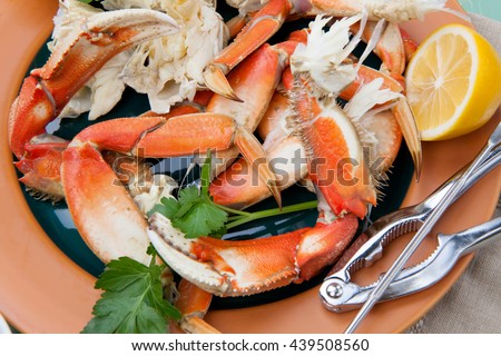 Assorted Dungeness crab legs with butter mustard sauce and fresh lemons.
 Royalty-Free Stock Photo #439508560