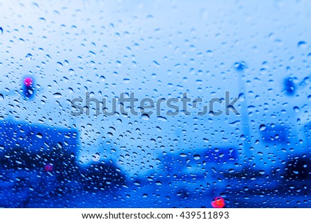 rain drops on window on road with blurred background