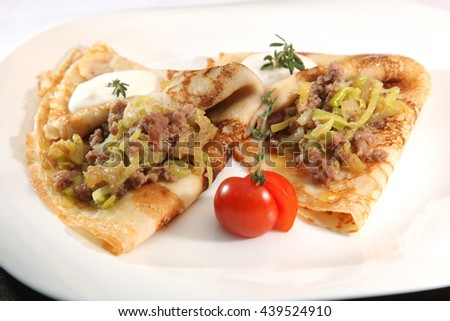 Pancakes with meat and onions on plate