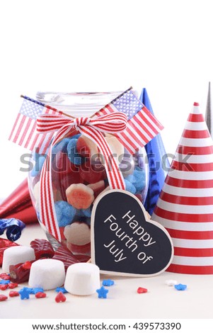 Happy Fourth of July patriotic jar of red, white and blue candy with flags on a white background. 
