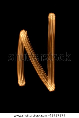The letter N from light, on a black background, it is isolated.