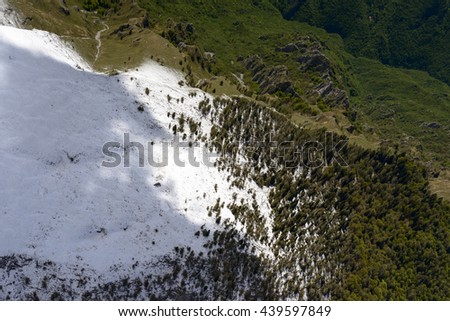 aerial shot, from a small plane, of the slopes of Arera peak range with recent springtime snow, shot in Orobie mountains, Bergamo , Italy
