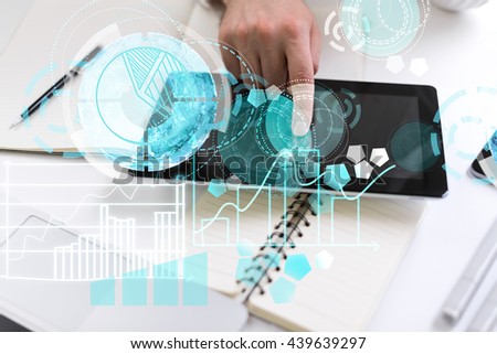 Top view of man hand using tablet with circular digital pattern on light desktop with stationery tools