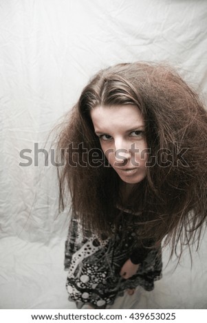 Shaggy freak girl on grey crumpled background