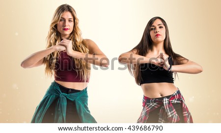 Two street dance girls over ocher background