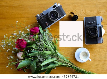 Beautiful Vintage Cameras with a colorful bouquet of flowers and decorative candles on the wooden table