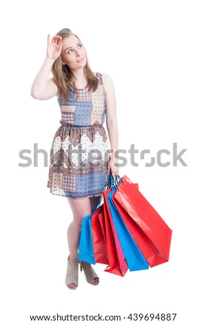 Beautiful shopaholic woman tired of shopping carrying a lot of gift bags isolated on white background