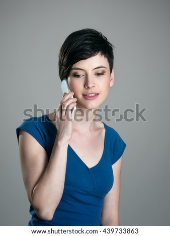 Feminine gorgeous short hair beauty talking on the cellphone looking down 