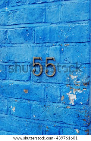 Blue bricked wall with number fifty-five. Windsor, England. Old blue house