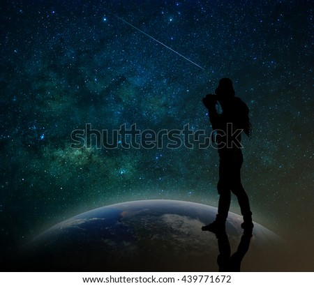 silhouette of a photographer who standing on the earth and taking photo the milky way background, Elements of this image furnished by NASA