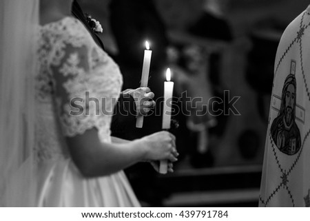 A black and white picture of candles held by bride and groom during the ceremony