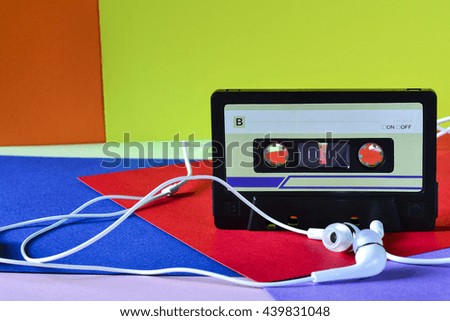 Retro cassette tape rubber with earphones on a colored background