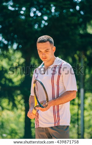 Picture of handsome young man on tennis court. Man playing tennis. 