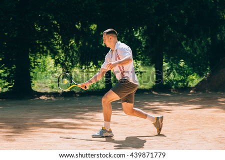 Picture of handsome young man on tennis court. Man playing tennis. 