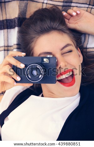 young happy woman laying with old film camera