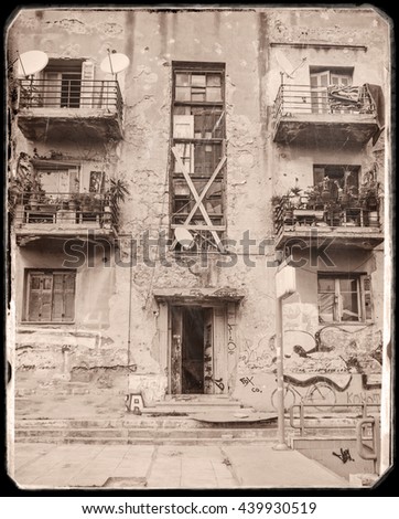 scene from old houses with bullet holes that have been destroyed from the Second World War. (now is shelter for homeless and immigrants). Photo in old image style.