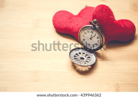 retro clock with two love heart yarn on wood stick on wood background with copyspace, love with time together concept.
