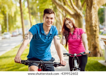Cycling young couple. In the park.Beautiful bicycle lane