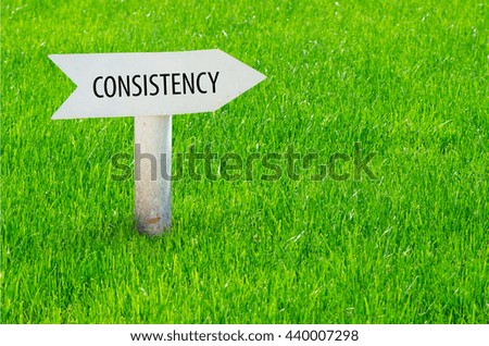 Consistency arrow sign in a grass field