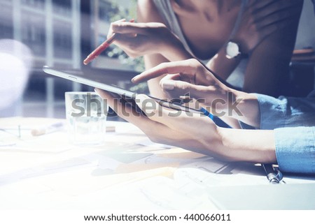 Closeup photo Girl Touching Screen Digital Tablet Hand.Project Producers Researching Process.Young Business Crew Working New Startup modern Studio.Analyze market stock.Blurred,flares effect.Horizontal